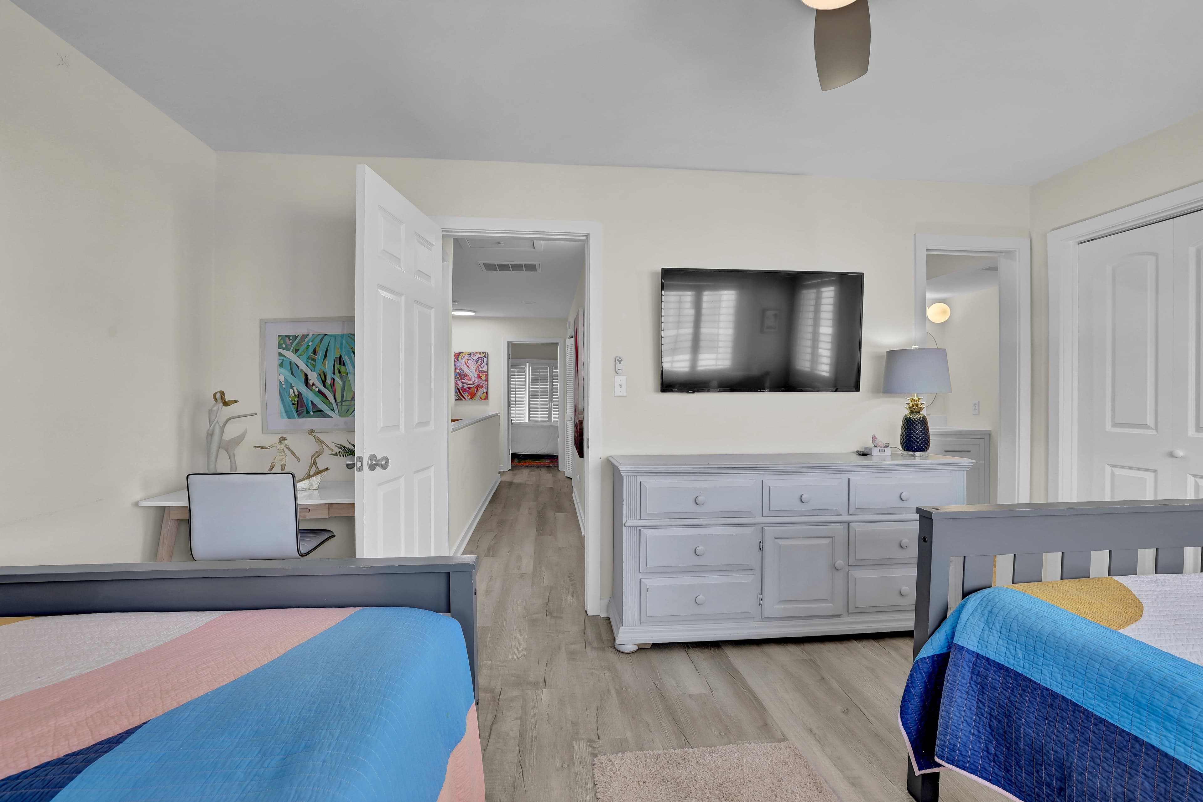 Bright double-bedroom with TV, dresser, and workspace for added comfort