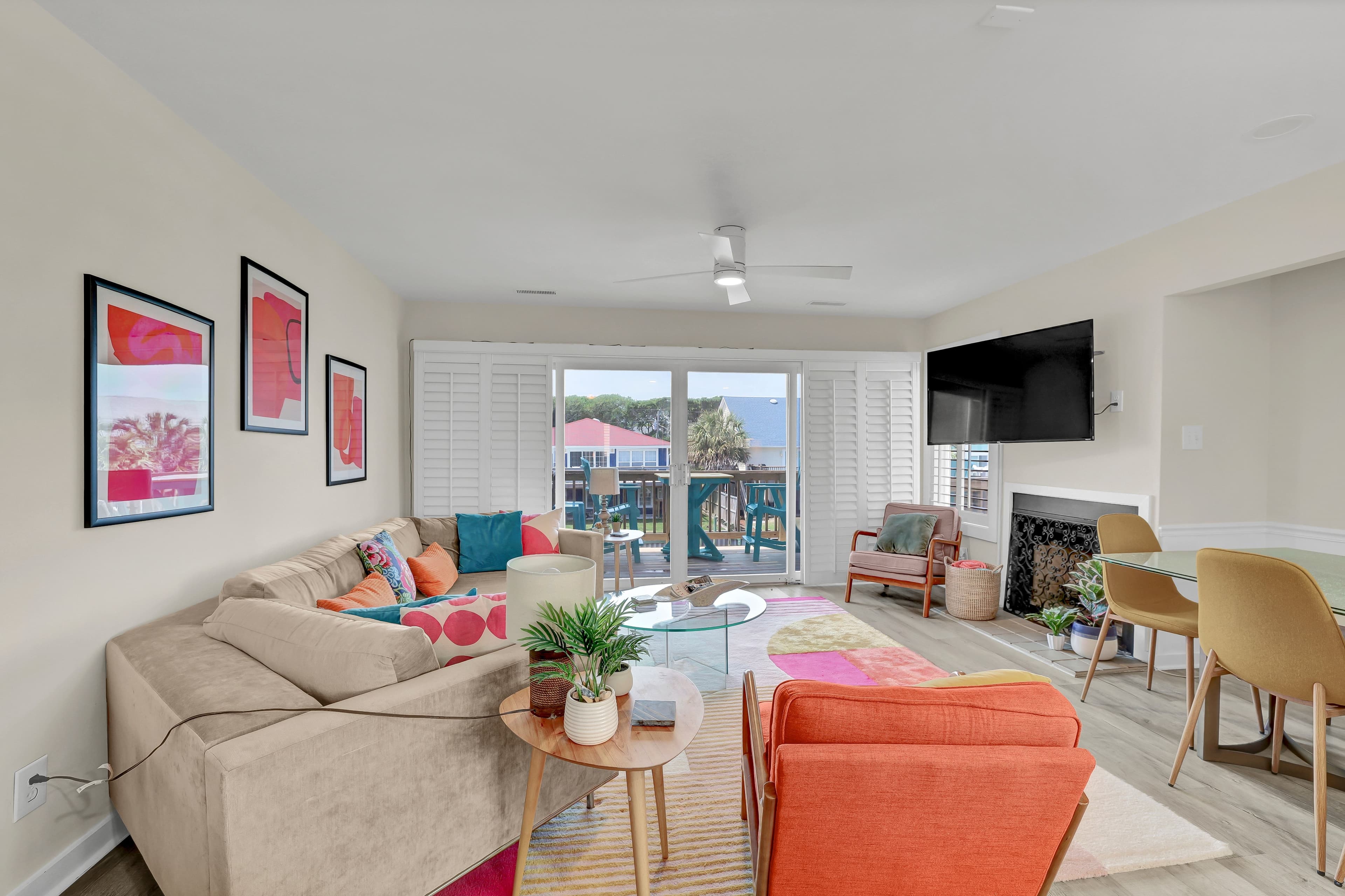Bright coastal-style living room with balcony views and colorful seating
