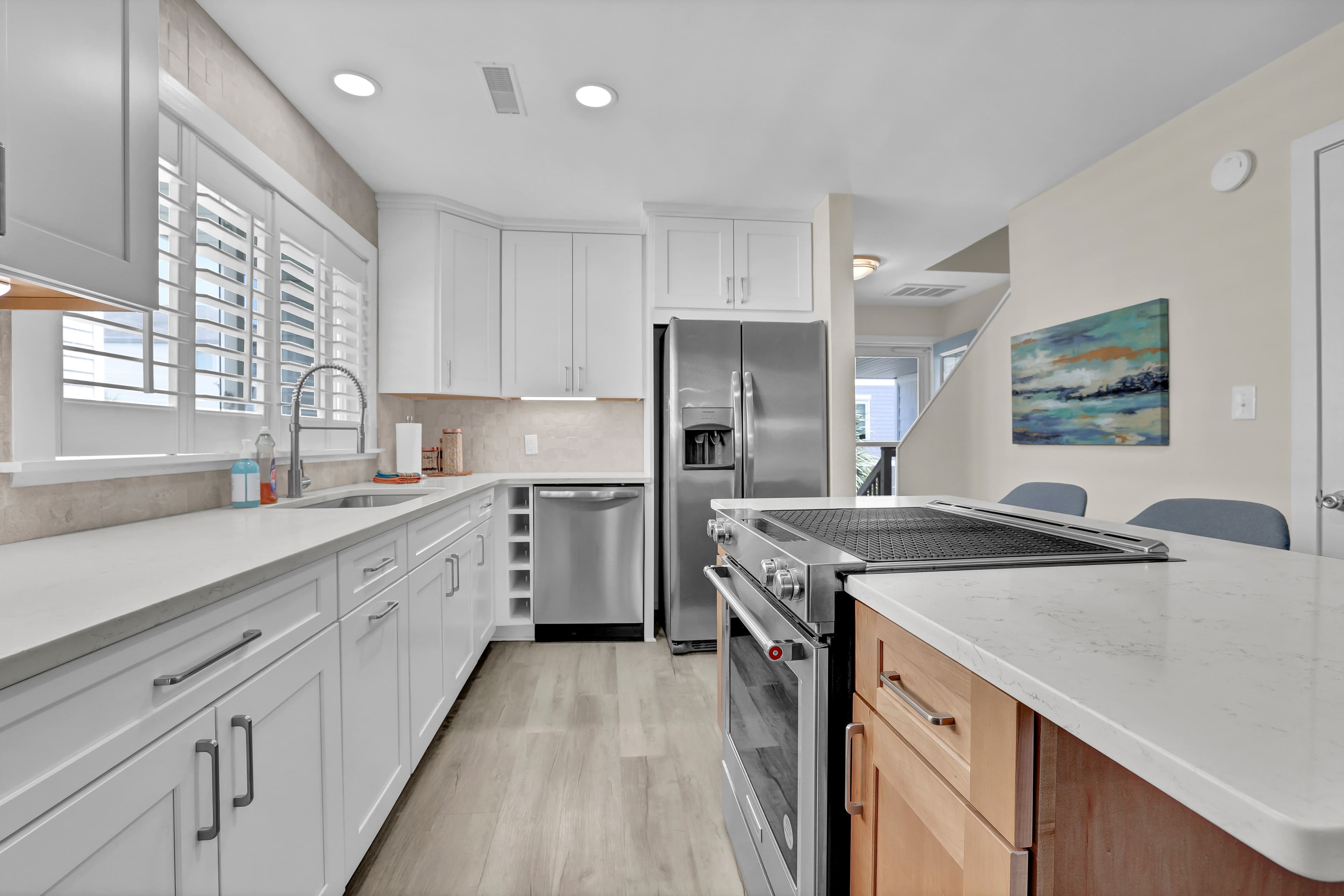 Bright modern kitchen with island, quartz counters, and stainless appliances