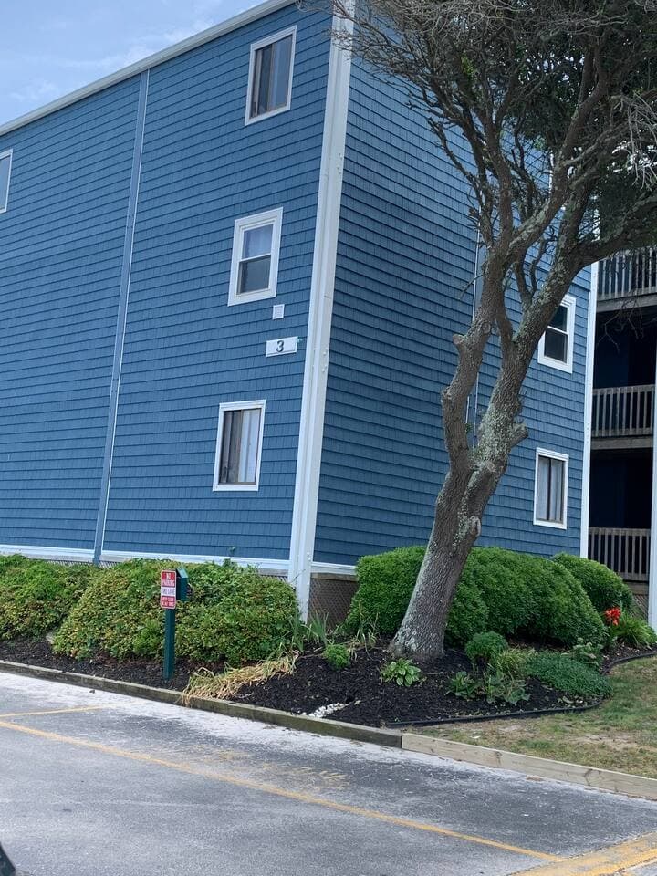 Building 3 is where Paradise Villa 228 is located. The newly sided buildings are welcoming with the beautiful flowers abounding all around the courtyard that surrounds an outside picnic table with umbrella. Laundry room is to left of the building.
