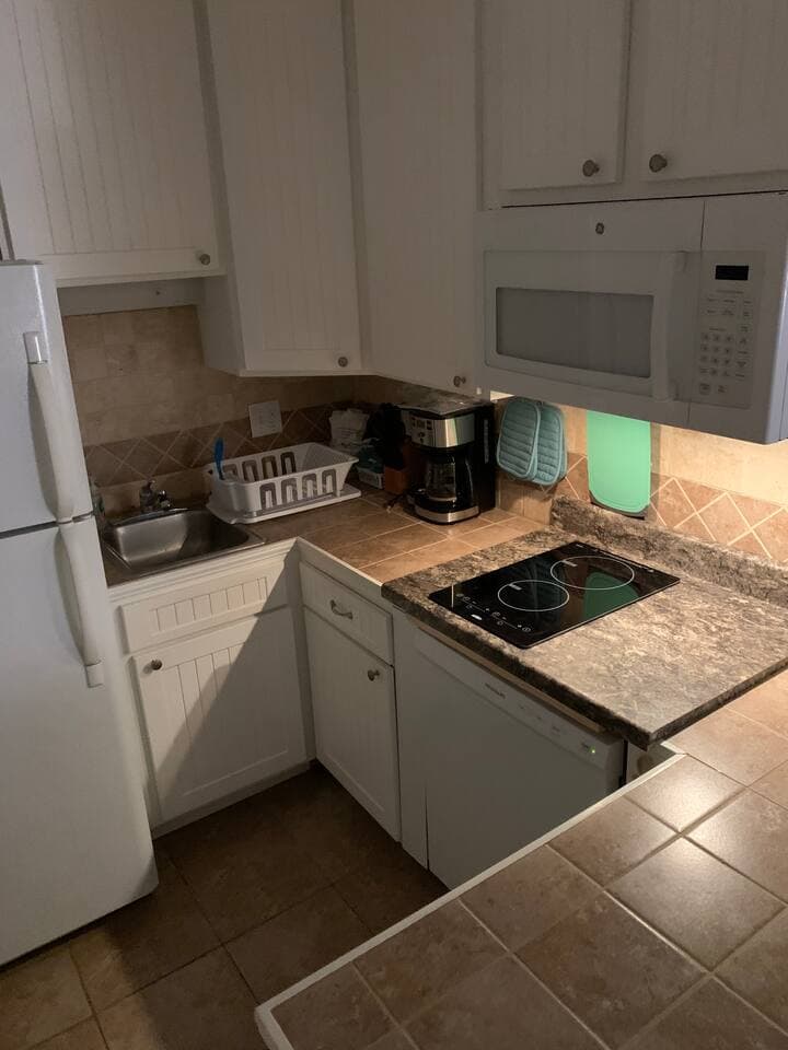 Full kitchen with brand new dishwasher, new induction cooktop, full size refrigerator with ice maker and new small appliances including a drip coffee maker, blender, and toaster. Large Microwave and all the needed dishware, silverware and cookware.