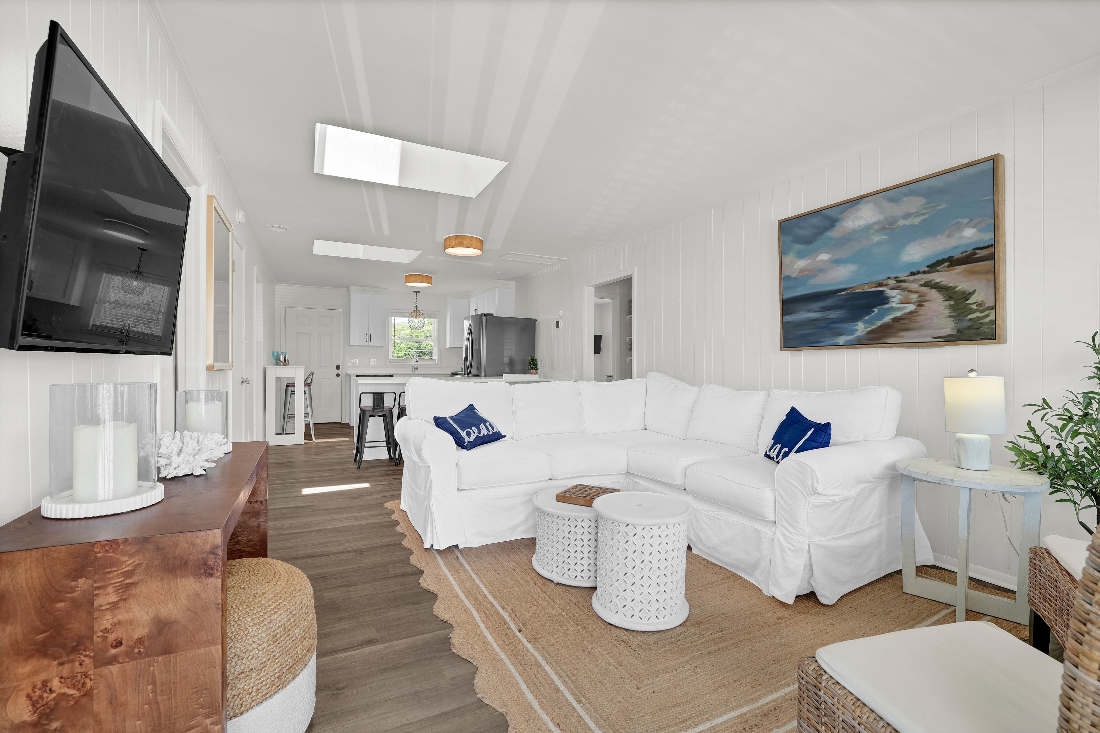 Bright coastal living room with spacious sectional and open kitchen