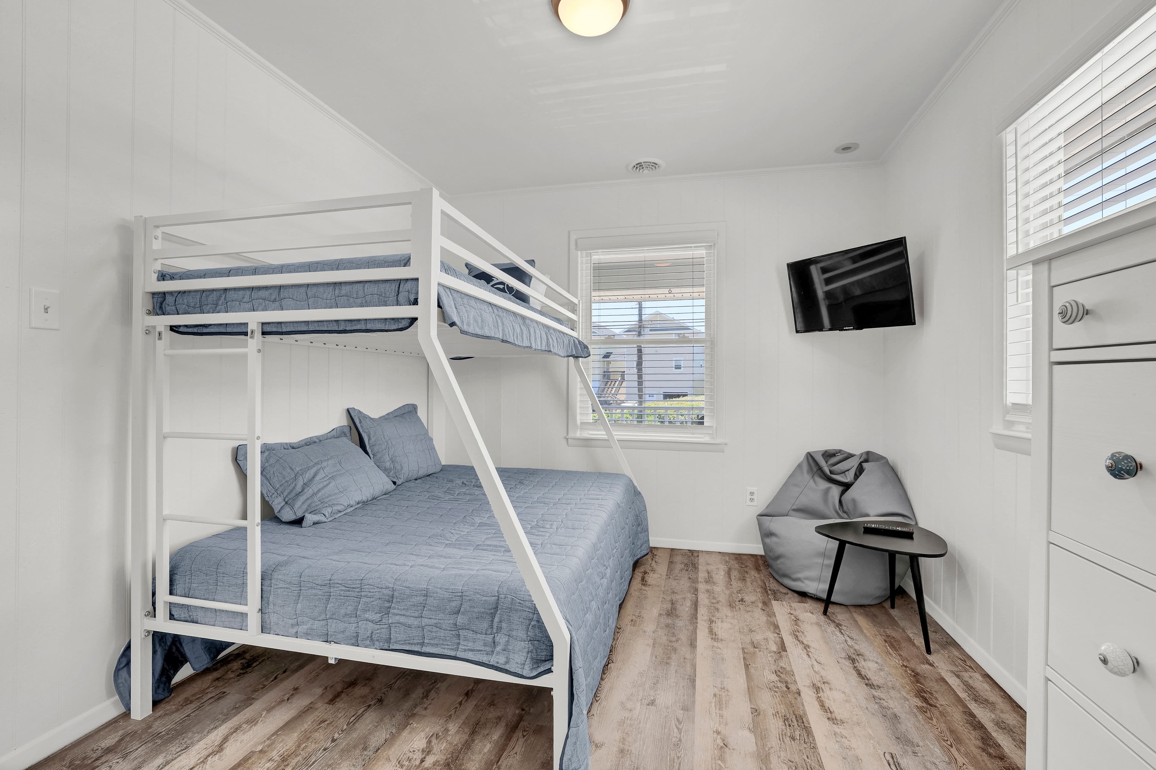 Bright bunk room with TV, cozy seating, and stylish modern finishes
