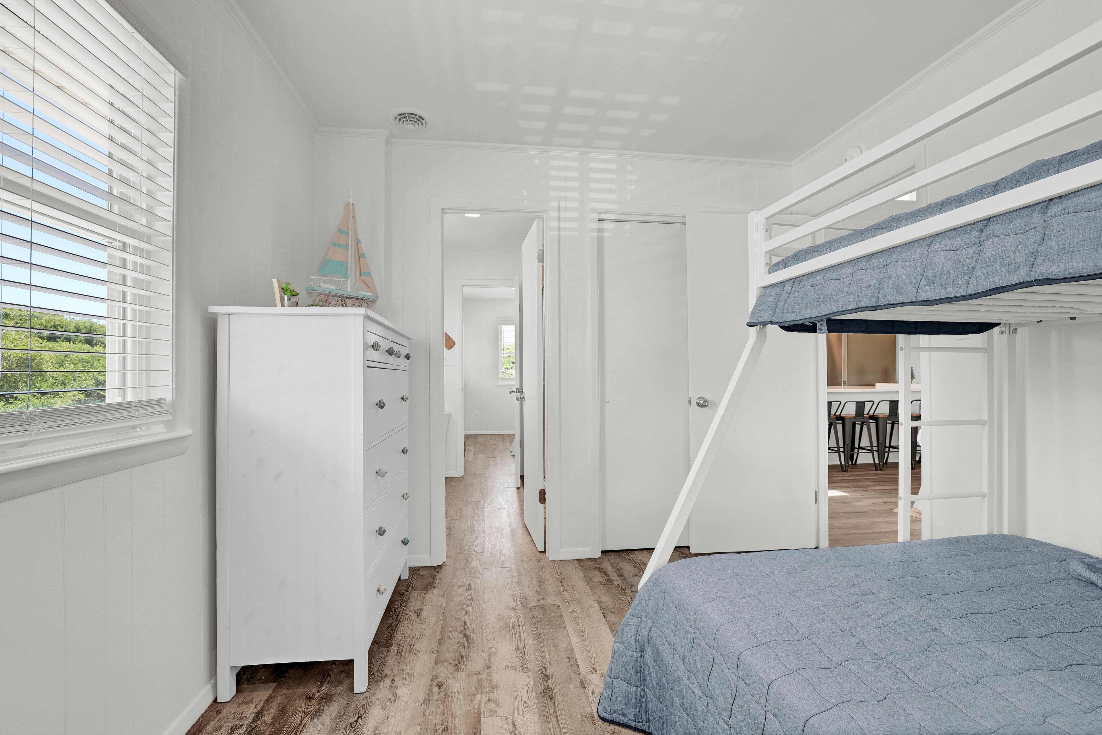 Bright bunk room with coastal charm, natural light, and family-friendly comfort